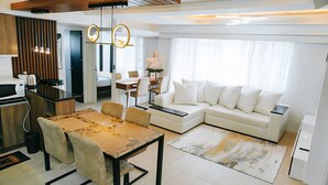 Una sala de estar moderna con un sofá blanco, una mesa de comedor y una zona de cocina.