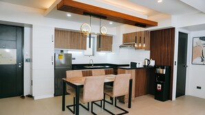 Una cocina moderna con zona de comedor, armarios de madera, un refrigerador negro y un dispensador de agua.