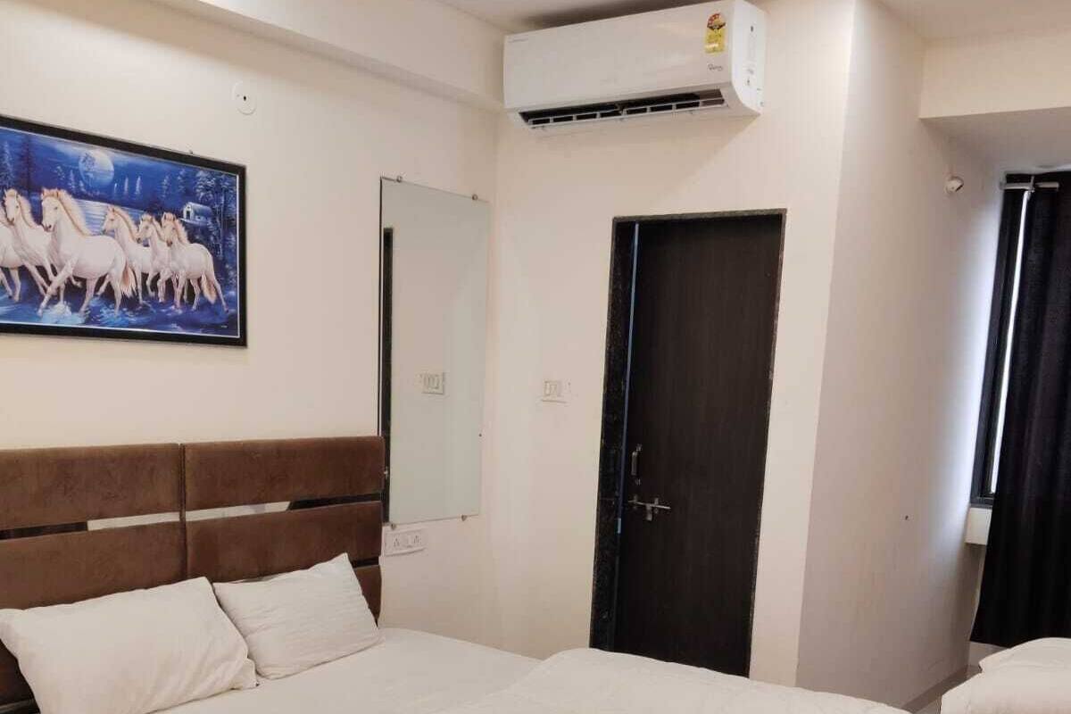 Hotelkamer met een groot bed, nachtkastje, kledingkast, airconditioning en een schilderij aan de muur.