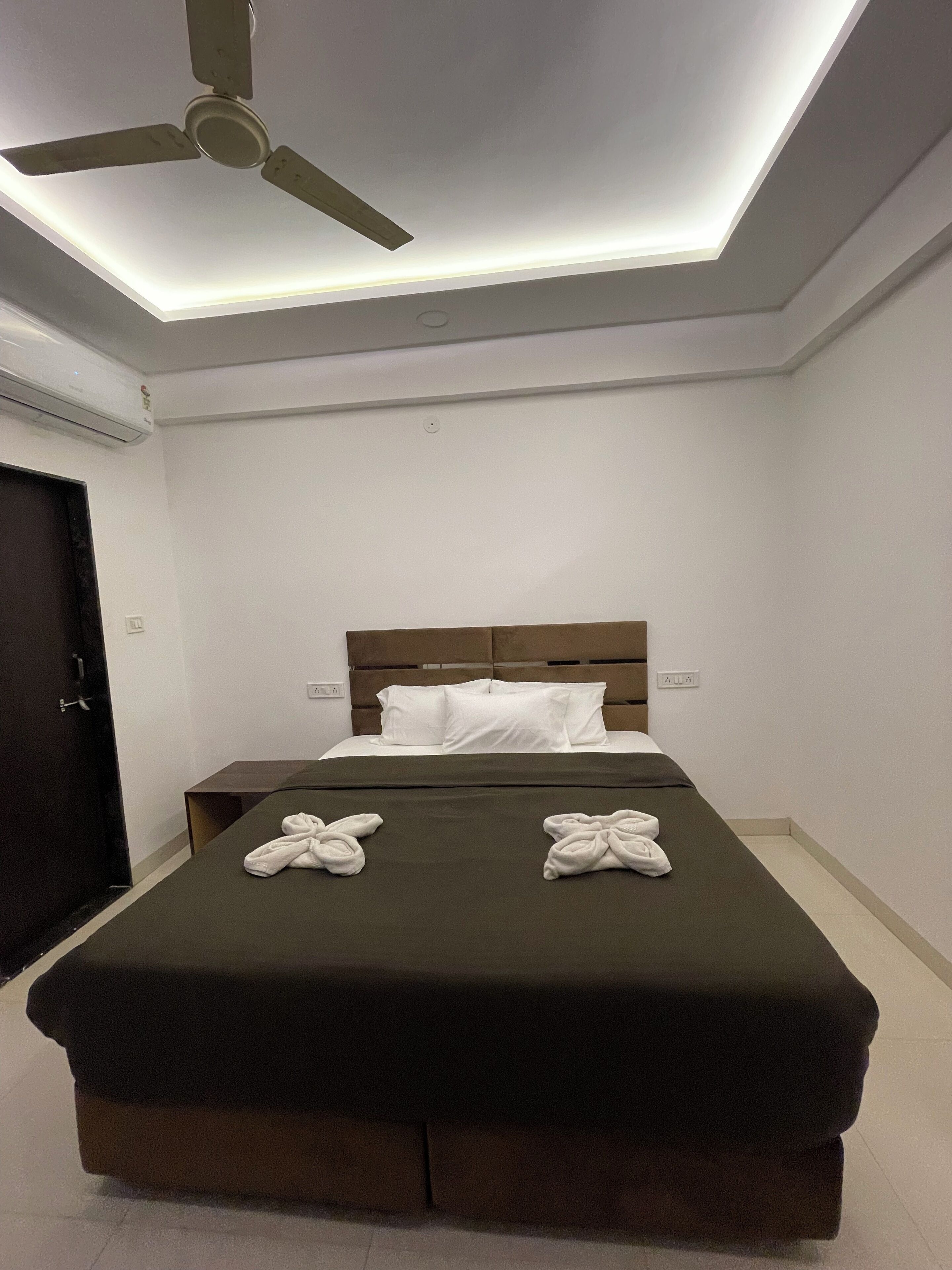 Una habitación de hotel con cama, ventilador de techo y diseño moderno.