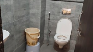 Ein modernes Badezimmer mit Toilette, Bidet und Waschbecken.