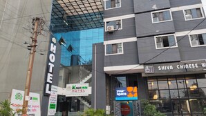 Ein Hotel mit moderner Glasfassade, Schilder mit der Aufschrift 'Shiva Chinese W' und 'Your Space' sowie einem sichtbaren Eingang.