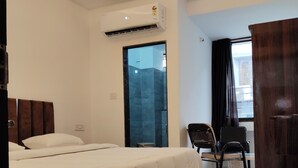 Ein modernes Hotelzimmer mit einem großen Bett, einem Schreibtisch und einem Stuhl.