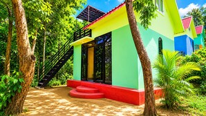 A colorful building with a staircase leading to a covered entrance, surrounded by trees. - Plankton Bungalow and Camping (Koh Rong)