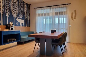 A dining area with a table and chairs, a sofa, and a coffee station. - Blocks Forest (Taitung)
