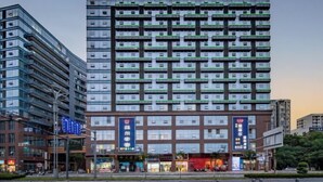 A multi-story hotel with a modern design, featuring a prominent entrance with signage and a series of balconies on each floor. - Eiffel International Hotel (Chengdu Hongpailou Metro Station) (Chengdu)