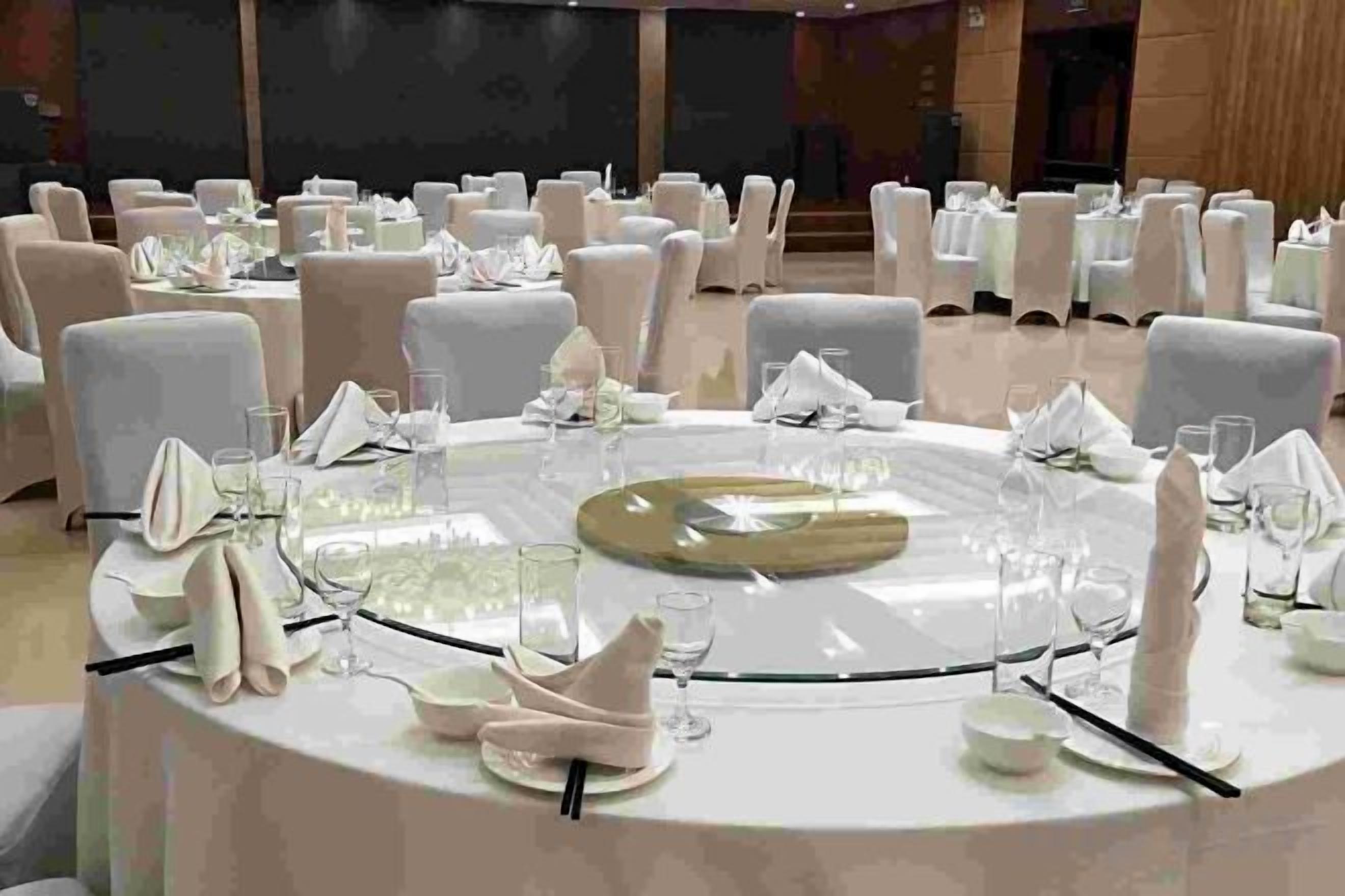 A round table set for a formal event with multiple chairs around it.