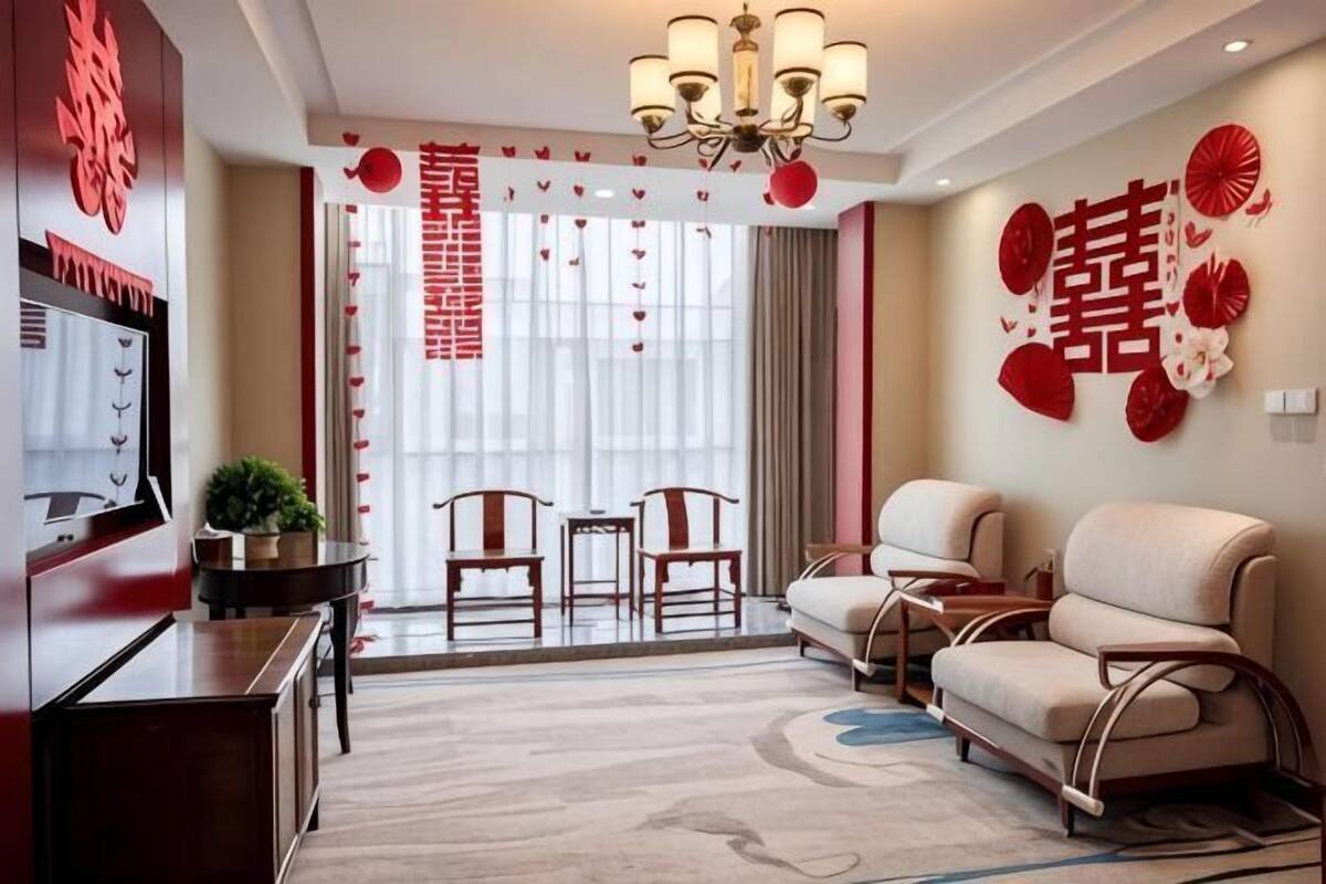 A living room with a sofa, chairs, a TV, and a chandelier.