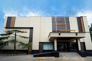 A hotel entrance with a modern design, featuring a prominent sign and a covered entrance area. - Dongsheng Hotel (Zouping)