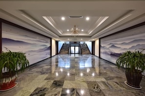 A spacious lobby with a marble floor, a chandelier, and a staircase leading to an upper level. - Dongsheng Hotel (Zouping)