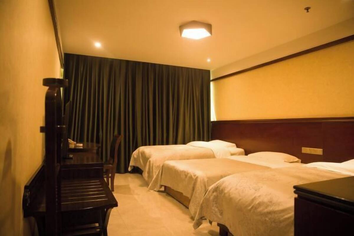 A hotel room with two beds, a desk, and a chair.