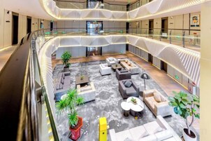 A multi-level atrium with seating areas, plants, and a central staircase.