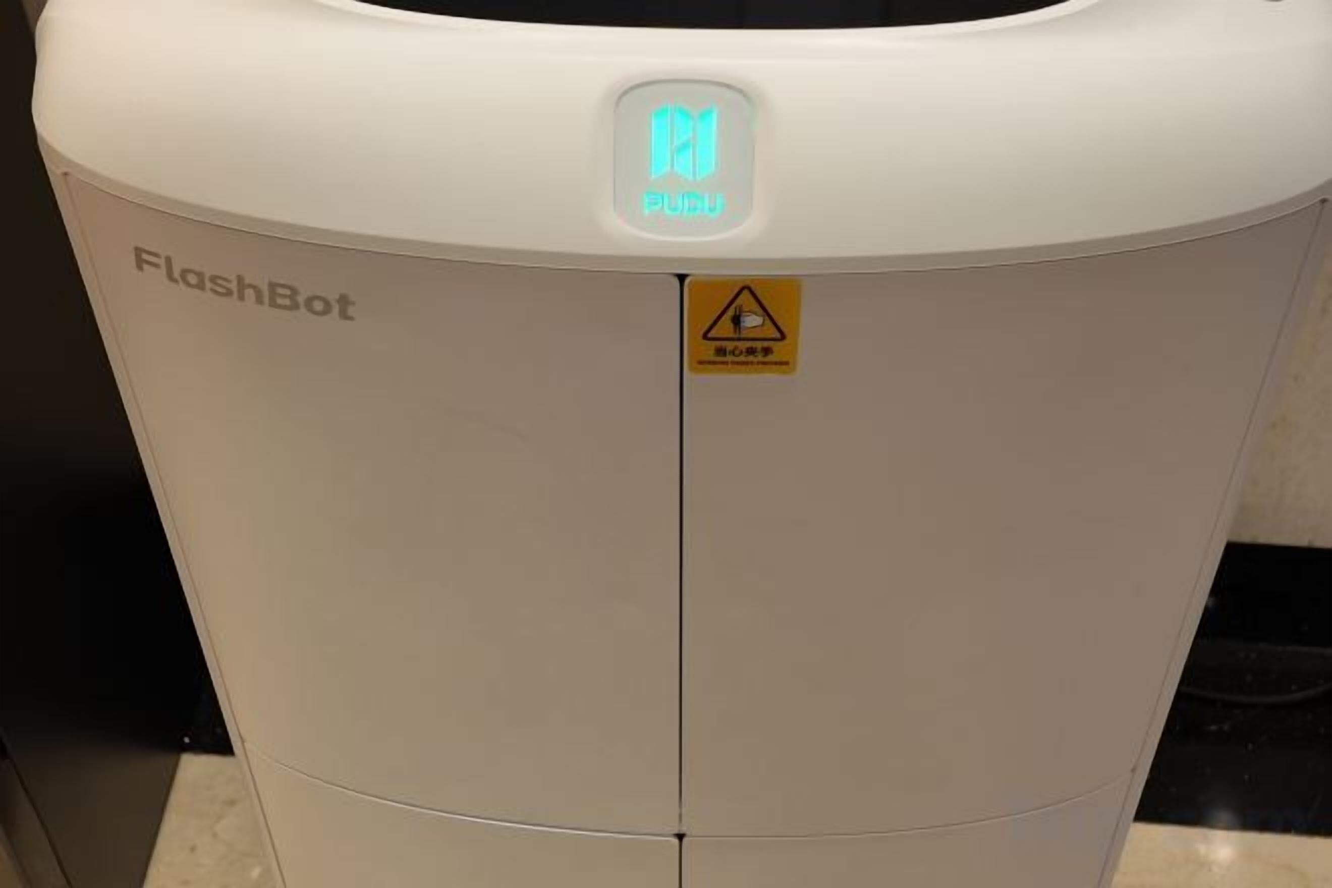 A white device with a warning label and the text 'FlashBot' on it.