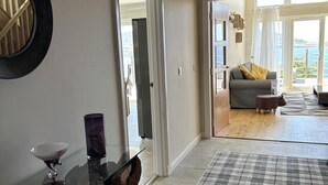 A spacious living area with a view of the sea, a modern chandelier, and a checkered rug. - Mull Tranquility Retreat (Isle of Mull)