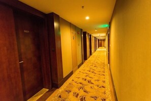 A hotel hallway with a patterned carpet, wooden doors, and a long corridor. - Zhongting International Apartment (Guangzhou Changgang Subway Station) (Guangzhou)