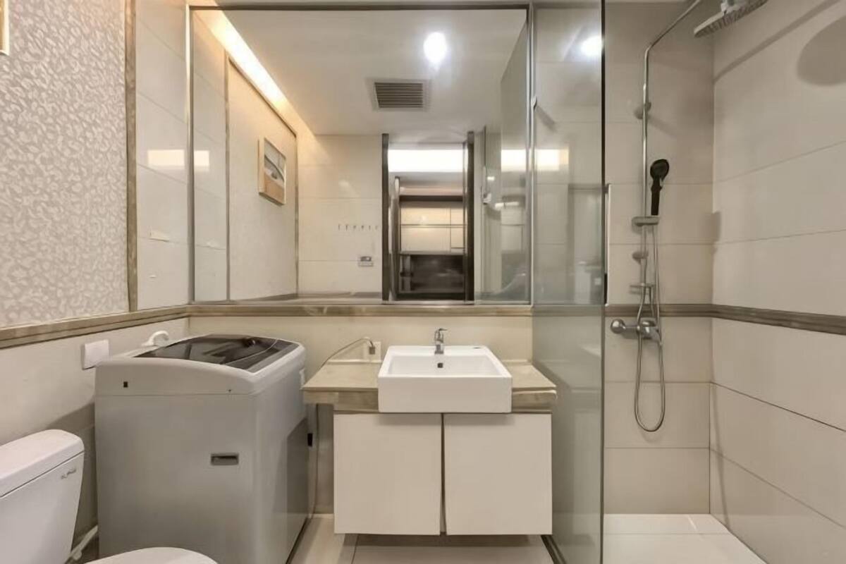 A bathroom with a toilet, sink, and shower.