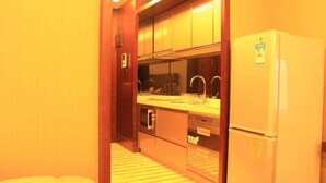 Una cocina compacta con refrigerador, pileta y horno.