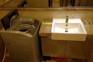 A washing machine and a sink in a bathroom. - Zhongting International Apartment (Guangzhou Changgang Subway Station) (Guangzhou)