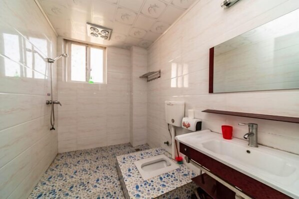 A bathroom with a toilet, sink, and shower. - Yuhui Inn (Wuyishan)