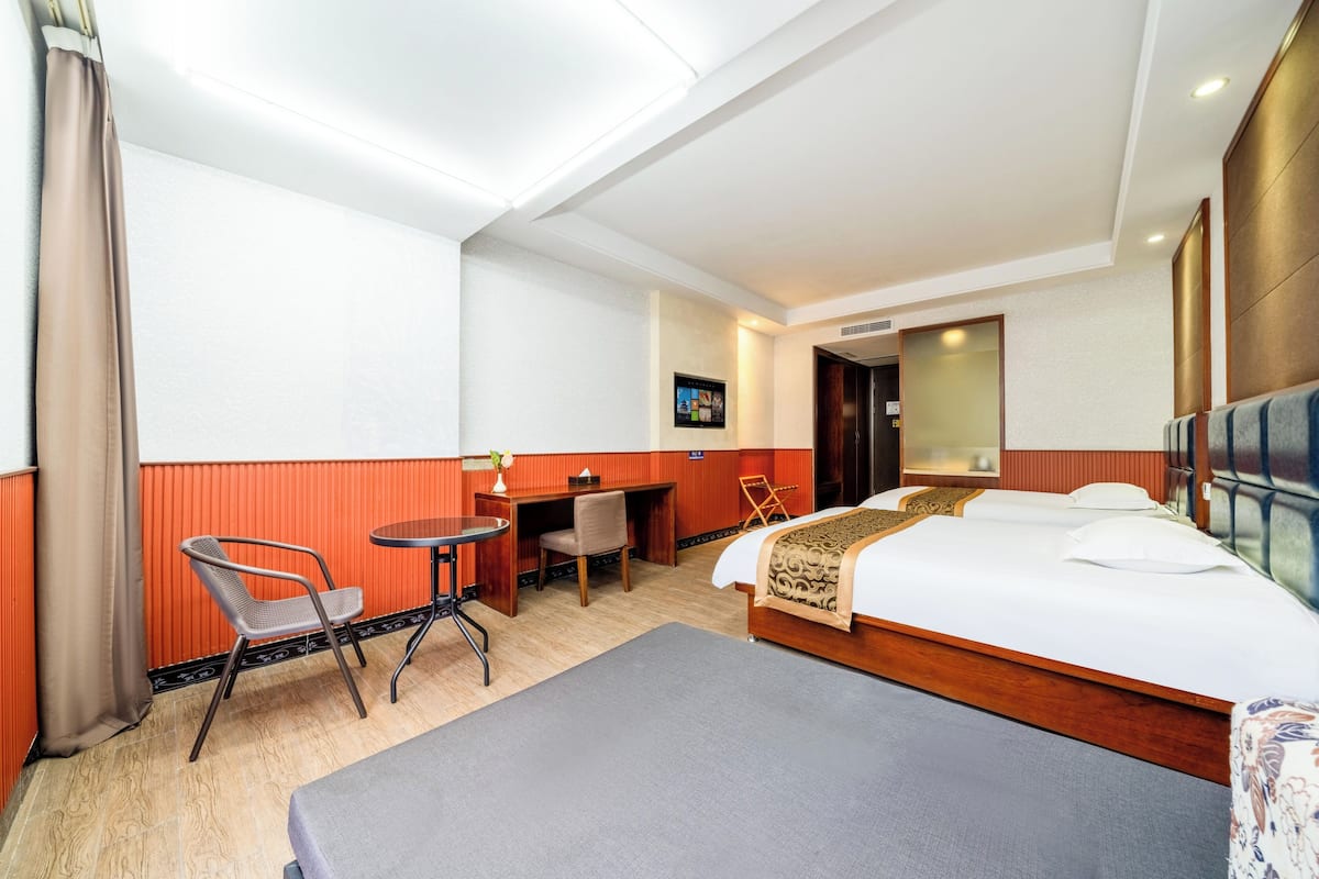 Ein Hotelzimmer mit einem Bett, einem Schreibtisch, einem Sessel und einem kleinen Tisch.