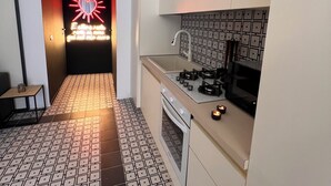 Una cucina moderna con pavimento piastrellato, piano cottura a gas e forno a microonde.