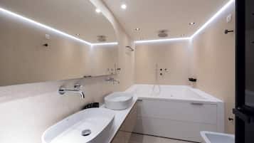 Ein modernes Badezimmer mit einem großen, ovalen Waschbecken, einer freistehenden Badewanne und einem separaten Handwaschbecken.