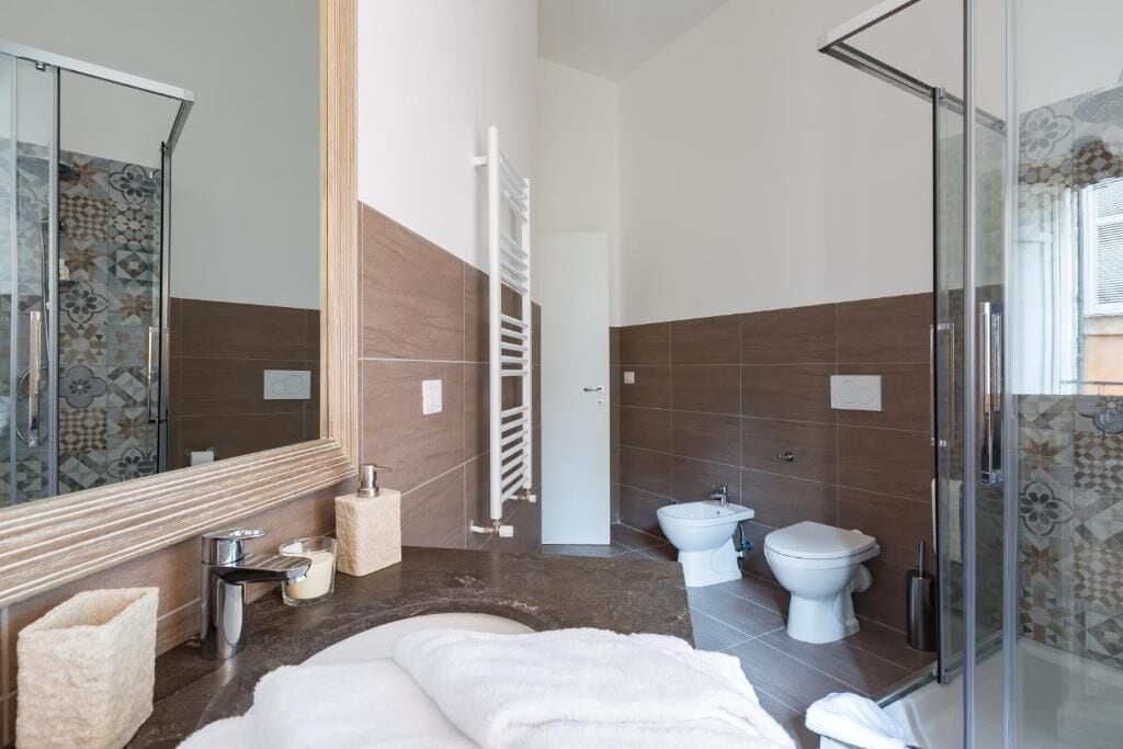 Un baño moderno con bañera, bidé, inodoro y cabina de ducha de vidrio.