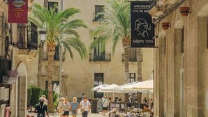 A street with outdoor seating, palm trees, and buildings with balconies. - Refined Studio Historic Center Alicante (Alicante)