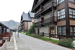 Une rue pavée bordée de bâtiments traditionnels en bois, dotés de balcons et de façades en pierre.