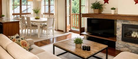 A cozy living room with a fireplace, a television, and a dining area with a table and chairs.