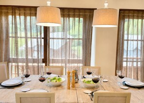 A dining table set for six with wine glasses, plates, and a bowl of salad. - BAQUEIRA URBANIZAC RUDA BLANHIBLAR APARTMENT FOR UP TO 7 PEOPLE (Baqueira)