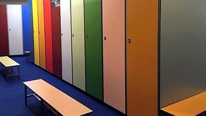 A row of lockers with a bench and table in a hallway.