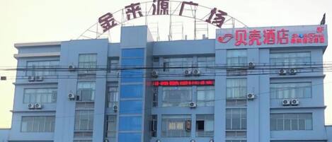 Un edificio de varios pisos con letreros que indican un hotel y un centro de negocios.