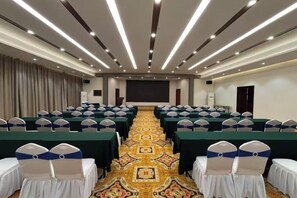 A conference room with rows of tables and chairs, a carpeted floor, and a projector screen. - Magnotel Hotel (Yangzhou East High Speed Railway Station) (Yangzhou)