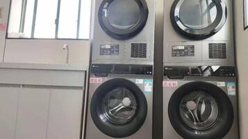 Un cuarto de lavandería con varias lavadoras y secadoras.