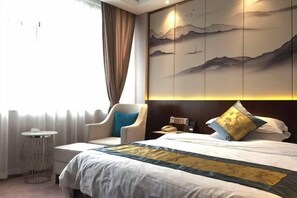 A hotel room with a bed, a chair, a small round table, and a wall with a decorative panel. - Hengfeng Hotel (Loudi)