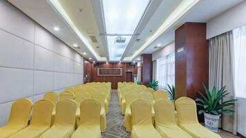 A conference room with rows of chairs, a podium, and a large window.