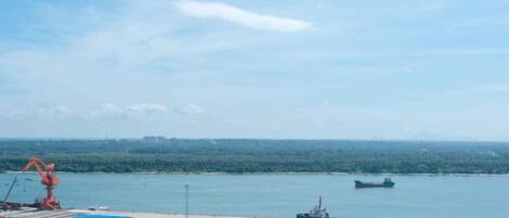 A coastal industrial area with a crane, a ship, and a dock.