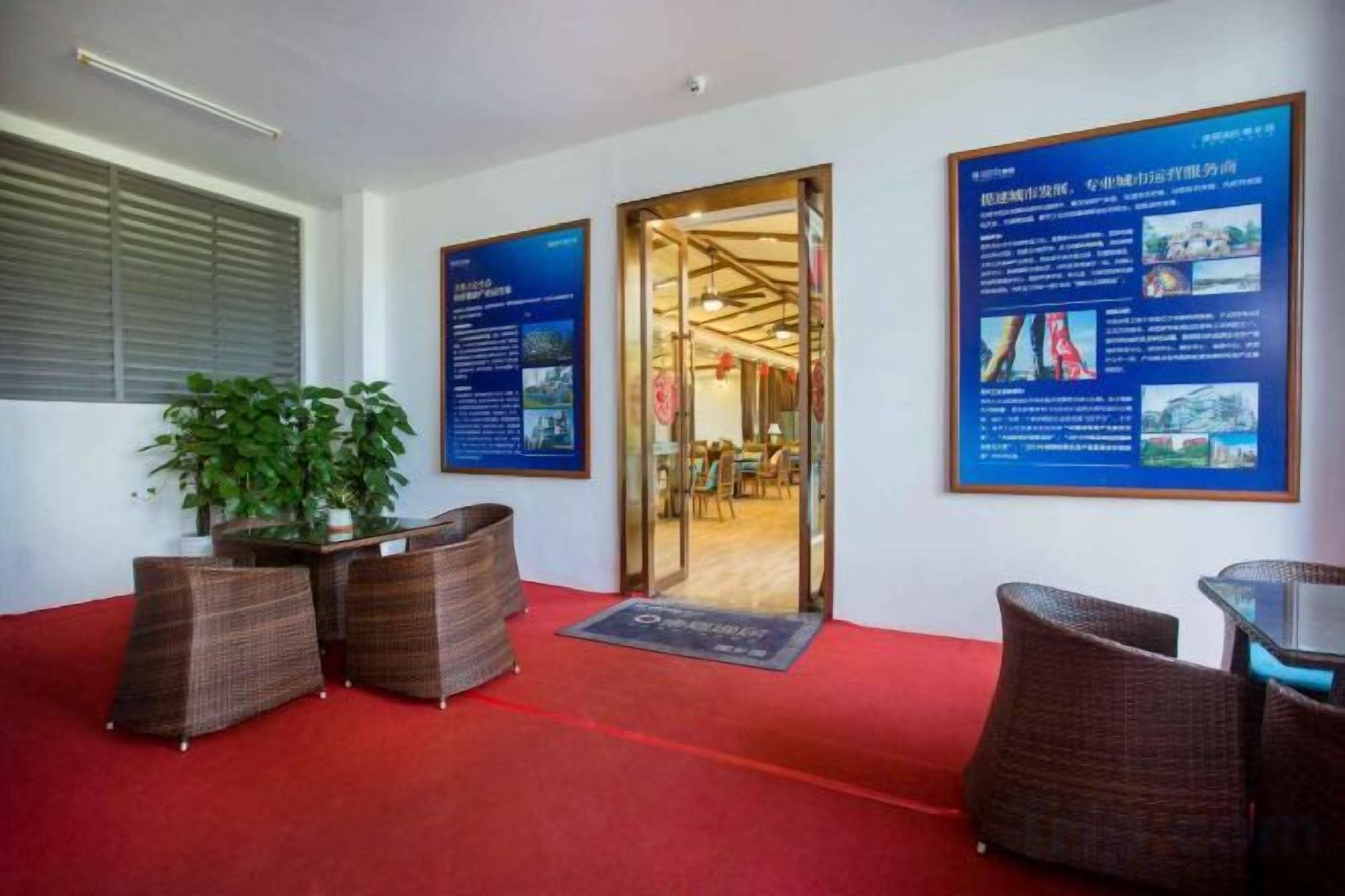 A reception area with a red carpet, wicker furniture, and informational posters on the wall.