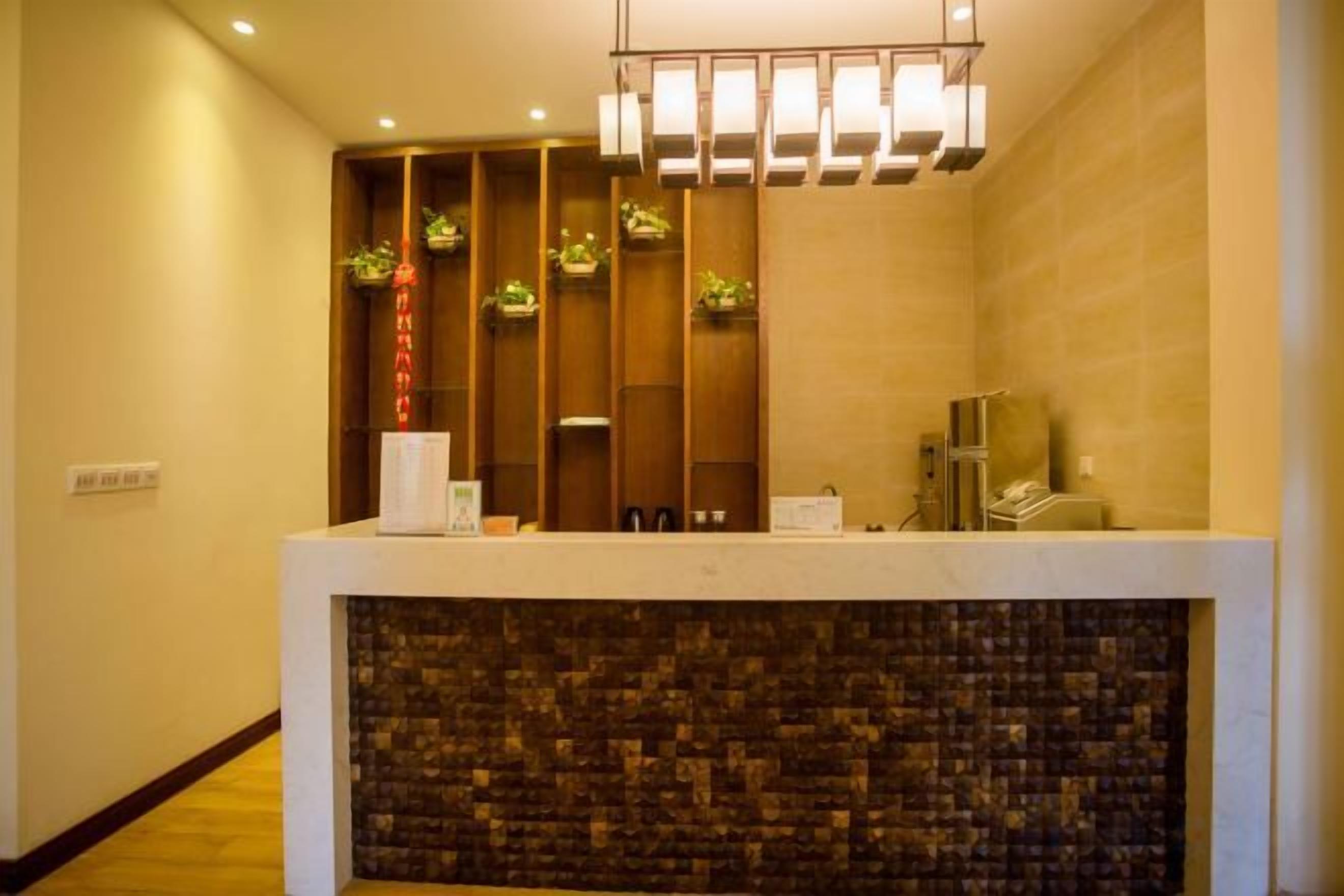 A reception desk with a modern design, a wooden panel wall, and a patterned stone wall below.