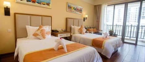 A hotel room with two beds, a balcony, and artwork on the walls.