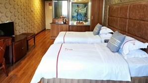 Una habitación de hotel con una cama grande, televisión, escritorio y armario.