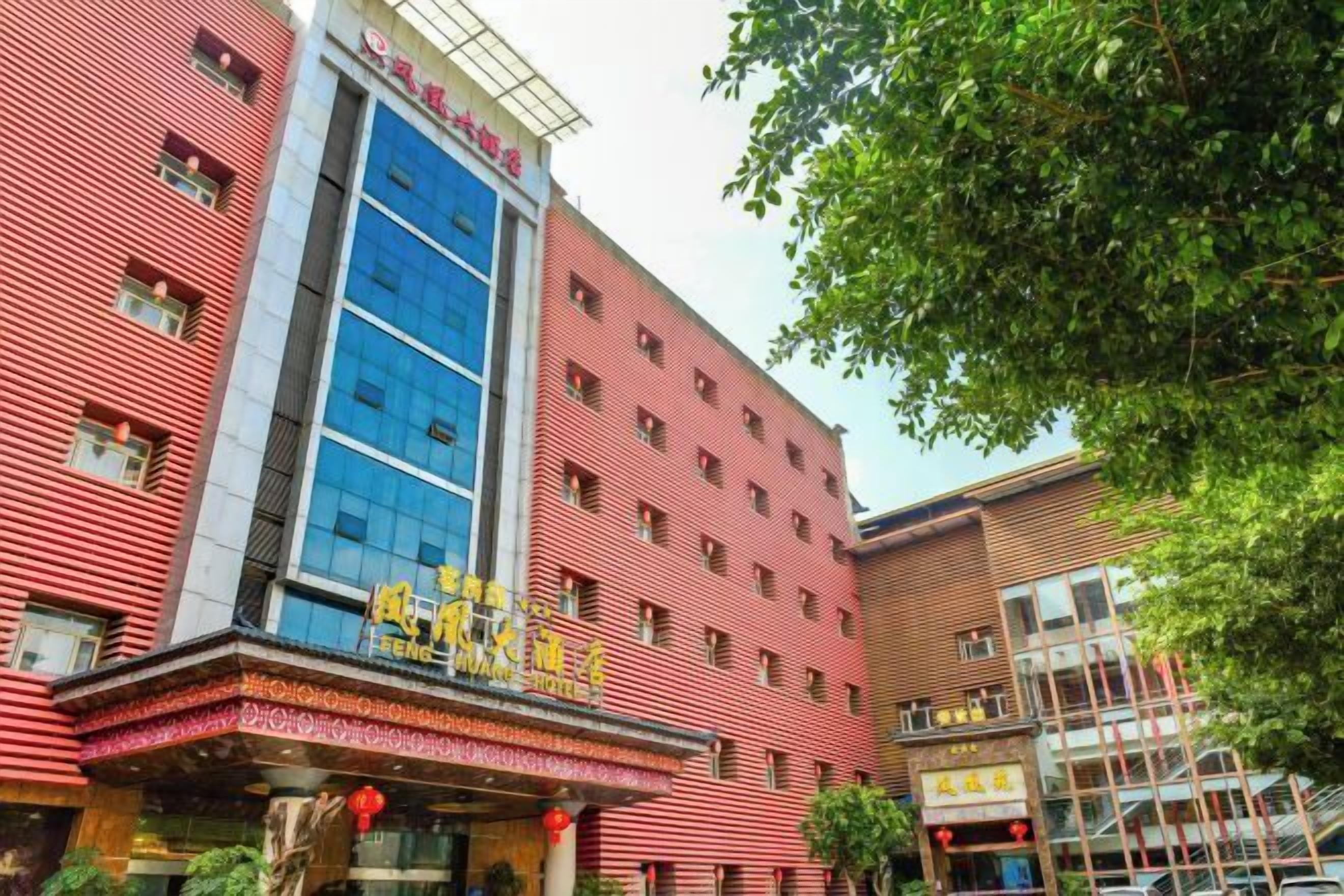 A hotel with a red facade, multiple windows, and a blue glass section.