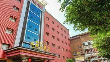 A hotel with a red facade, multiple windows, and a blue glass section.