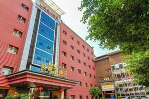A multi-story hotel with a red facade and a blue glass elevator. - Phoenix Hotel (Xichong)