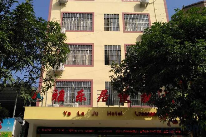 A hotel with a yellow facade, multiple windows, and a sign with red lettering.