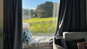 Ein Zimmer mit großem Fenster, einer Couch und einem Kissen.