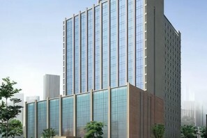 Un immeuble moderne de grande hauteur, doté d’une façade en verre et d’un toit plat.