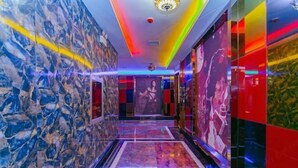 Un couloir aux murs de marbre et au plafond aux couleurs vives.