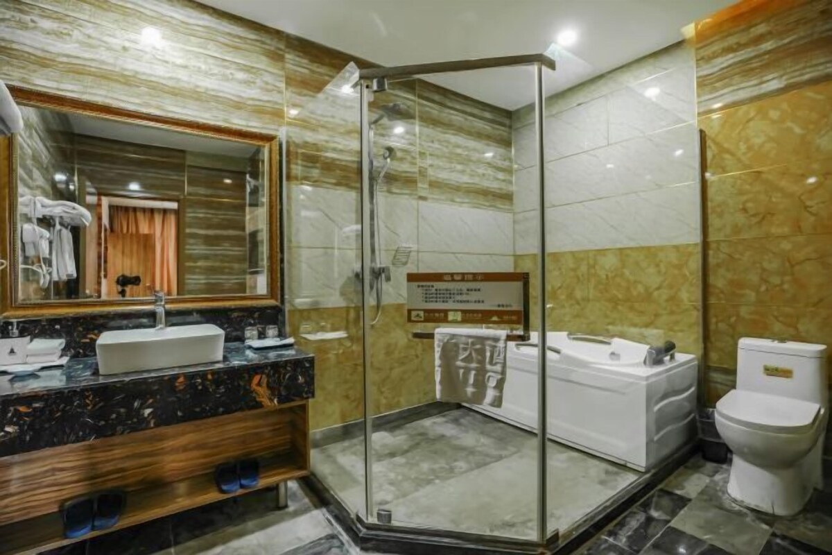 Ein modernes Badezimmer mit einer Duschkabine, einem Waschtisch mit Marmorplatte und einer separaten Badewanne.